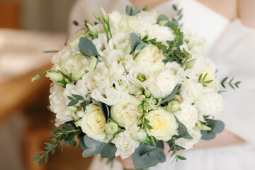 The bride is holding a wedding bouquet of flowers. Close-up