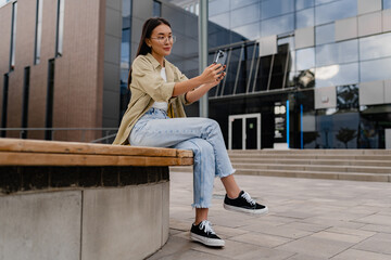 young pretty woman sitting in student campus co-working outside