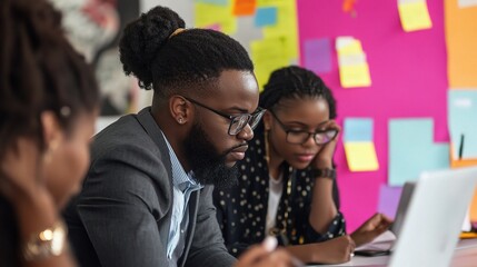 Focused Collaboration: A diverse team of creative professionals work together in a vibrant office space, focused on their tasks