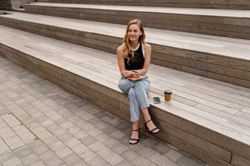 Obraz premium young pretty woman sitting in student campus co-working outside