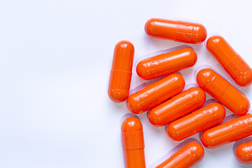 Orange pill capsules isolated on white background,Medicine background. Orange pills isolated on white. Pile of capsules. Tablets background. Vibrant vivid color drugs. Antibiotics background. Empty co