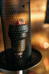 The glowing embers of a hookah in close-up. Protective grate