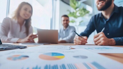 Business Meeting Focus: A close-up perspective of a business meeting, with papers and a laptop spread out on the table, highlighting the focused collaboration and  discussion among colleagues.  