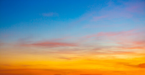 Fototapeta premium Colorful clouds and sky. Dusk and sunset. Evening clouds with orange, yellow, pink and red sunlight and amazing storm clouds in the dusk sky.