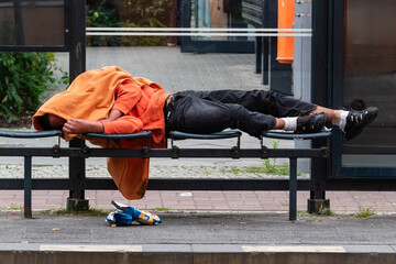 Homless Man sleeping in a Tram Station, A drunk person lies in a tram stop and sleeps off his...