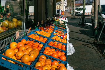 A fruit stand with lots of oranges on the sidewalk, Fruit Shop, Sidewalk, many oranges in baskets