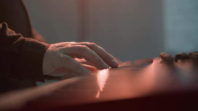 Closer side view of a keyboardist's hand playing a red sampler piano. The detailed shot highlights the musician's precise finger movements on the keys