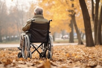 An elderly Caucasian man with disabilities rides on a chair in the park in autumn. Back view of a person on a walk in a wheelchair. Old age, Healthcare, Hope and mental strong people concept