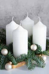 Advent wreath with four white candles, fir branches on a light gray background. Sunday December.Traditional diy Christmas decoration, holidays concept.