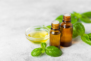 Basil essential oil on a textured wooden background. Basil essential oil and fresh leaves. Aromatherapy. Aroma oil. Medical herbs. Alternative medicine. Place for text. Copy space.