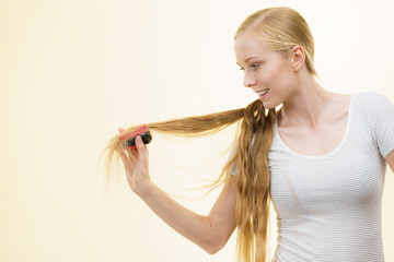 Blonde girl brushing her long hair