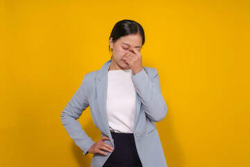 Young asian businesswoman touching her nose and keeping eyes closed, suffering from headache...