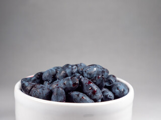 Fresh Honeyberries in a White Cup
