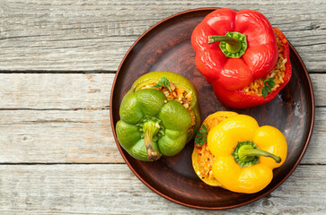 Baked stuffed pepper ( paprika ) with rice , carrot and meat . Top view on rustic background