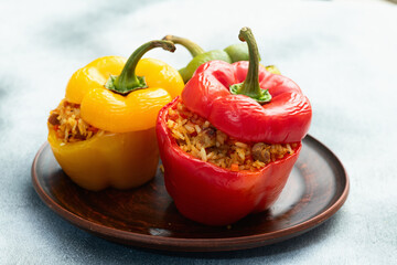 Baked stuffed pepper ( paprika ) with rice , carrot and meat . Top view on rustic background