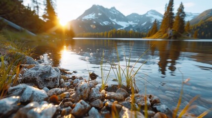 A stunning sunrise lights up a tranquil mountain lake with a rocky shoreline, reflecting the beauty of nature with crisp water, mountain peaks, and lush greenery.