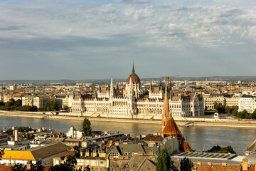 Fototapeta premium Budapest Hungary. View of the capital in Europe. Cruises ship passes on the Danube River. The imposing Parliament in the background. The bridges with cars, trams and bicycles. Concept photo