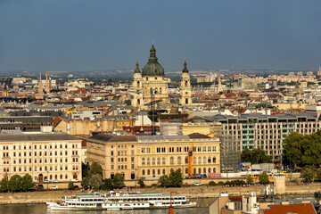 Obraz premium Budapest Hungary. View of the capital in Europe. Cruises ship passes on the Danube River. The imposing Parliament in the background. The bridges with cars, trams and bicycles. Concept photo