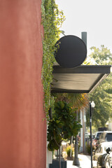 Black round sign with copy space on urban road with a leading wall