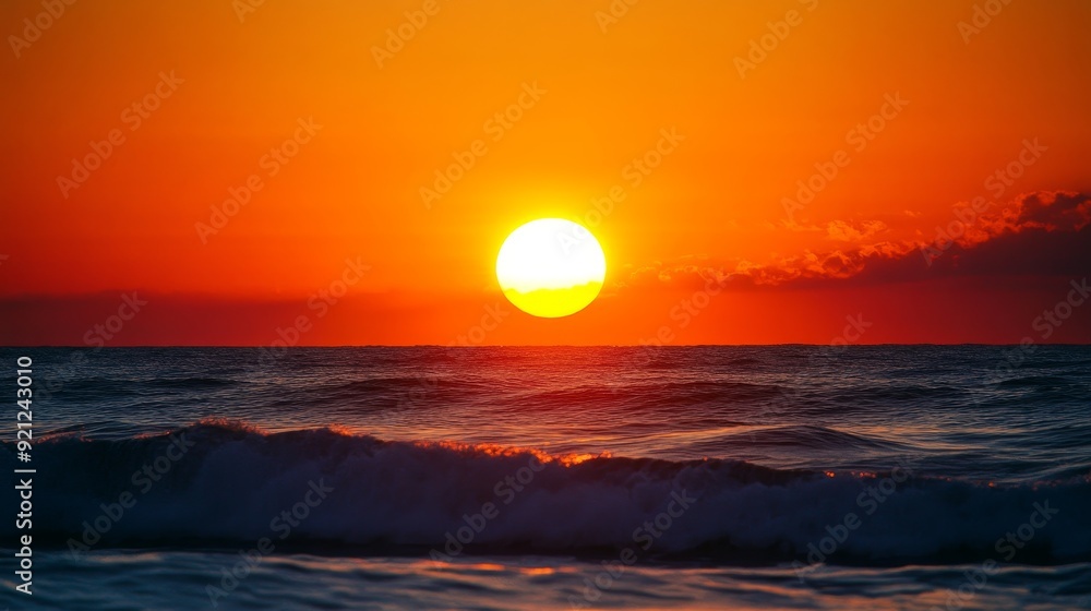 Sticker A vibrant sunrise paints the sky with fiery hues as the sun peeks over the horizon, casting a golden glow on the gently rolling waves of the ocean.