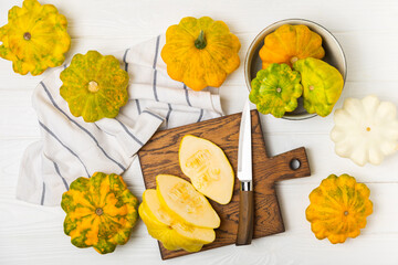 Pattypan zucchini on a textured kitchen table. squash. Fresh organic pattypan squashes on...