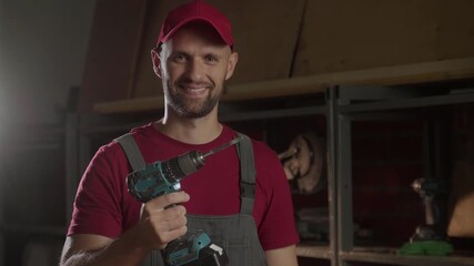 A carpenter focuses on his work as he holds a screwdriver, engaging directly with the camera. He showcases his skills in a well-equipped workshop, surrounded by tools