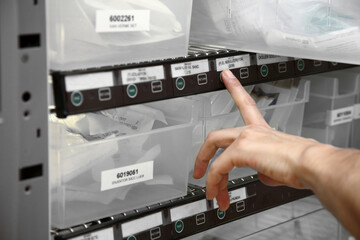 pharmacist selects medicine from hospital medicine automation system by scanning her finger. Pyxis drug station, automation system
