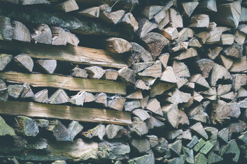 Background of dry chopped firewood logs stacked up on top of each other in a pile