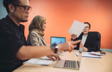 business muslim and asian woman and man have meeting. diversity people with asian woman and man and hijab person having a conversation about project at workplace. in conference room people is debate