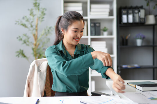 Smiling businesswoman rolling up her sleeves getting ready to work on a new project
