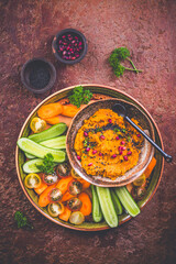 Spicy carrot spread, dip, hummus with raw snack vegetables