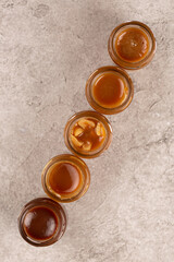 Homemade caramel with different flavors in glass jars