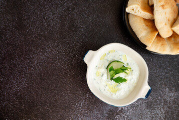 Tzatziki sauce. Gray grunge background. Greek sauce made from yogurt and vegetables. Top view, flat lay, copy space