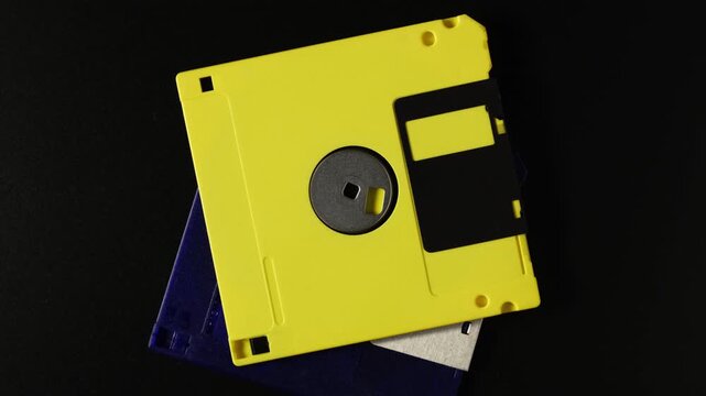Computer equipment. Retro 3.5" floppy diskette, top view. Concept of computing, computer, storage, vintage, disk and data storage. Floppy disk on dark turntable.