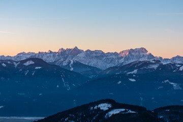 Scenic view of snow capped mountain range of Julian Alps at sunrise seen from Kobesnock, Bad Bleiberg, Carinthia, Austria, Europe. Remote wilderness in snow covered winter wonderland in Austrian Alps