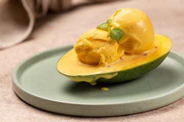 Balls of natural mango ice cream on a slice of ripe mango