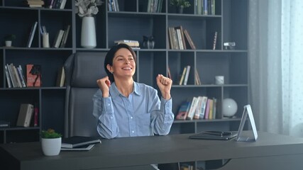 Successful professional woman cheering in modern office workspace