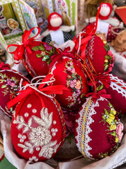 Easter eggs decorated with red fabric, ribbons, embroidery and lace, top view