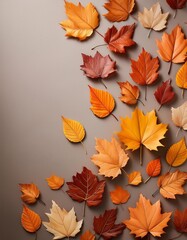 Fototapeta premium Autumn Leaves- A scattering of autumn leaves on a neutral background, with plenty of room for text or fall-themed products