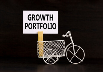 Growth portfolio symbol. Concept words Growth portfolio on beautiful white paper on wooden clothespin. Beautiful black background. Bike model. Business Growth portfolio concept. Copy space.