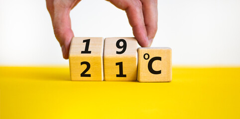 19 or 21 degrees Celsius symbol. Concept word 19 or 21 degrees Celsius on cubes. Beautiful yellow table white background. Lowering temperature to reduce energy consumption concept. Copy space.