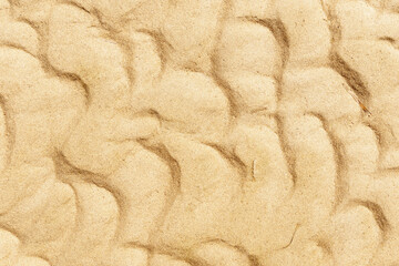 Wet golden sand detail on sea beach, Grado, Italy