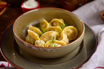 Authentic Ukrainian Dumplings with Sour Cream and Dill in Rustic Setting