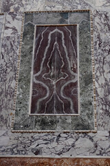 Close-up of a symmetrical gray marble pattern on a tile surface, showcasing intricate veining and natural stone texture, perfect for interior design.
