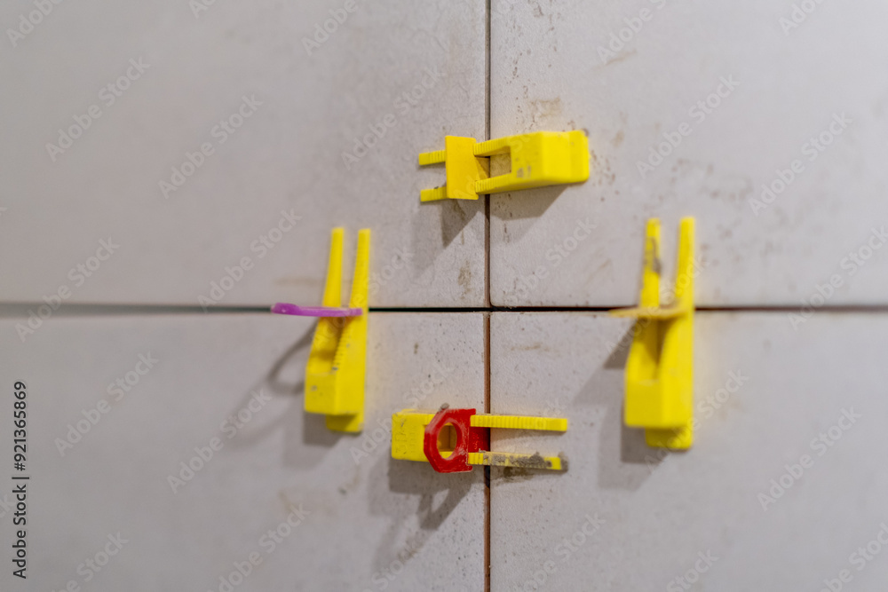 Aufkleber tile leveling system with plastic clips and wedges in action. ensures precise