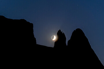 silhouette of a moon in the mountains