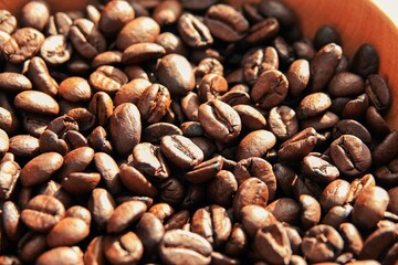 Un tas de grains de café à la lumière du soleil, avec effet de lumière chaude et ombres marquées