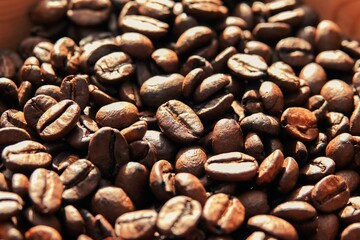 Un tas de grains de café à la lumière du soleil, avec effet de lumière chaude et ombres marquées