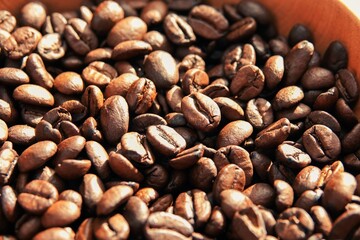 Un tas de grains de café à la lumière du soleil, avec effet de lumière chaude et ombres marquées