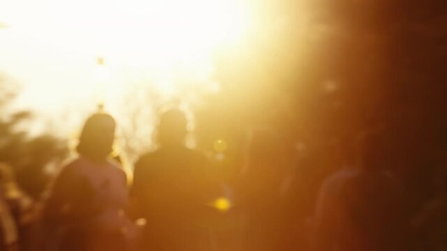 Bokeh blurred people crowd walking busy street slow motion shot, city life, lot of unrecognizable pedestrians, brightly lit crowded sidewalk, urban rush hour summer day. Sun beams warm orange sunlight